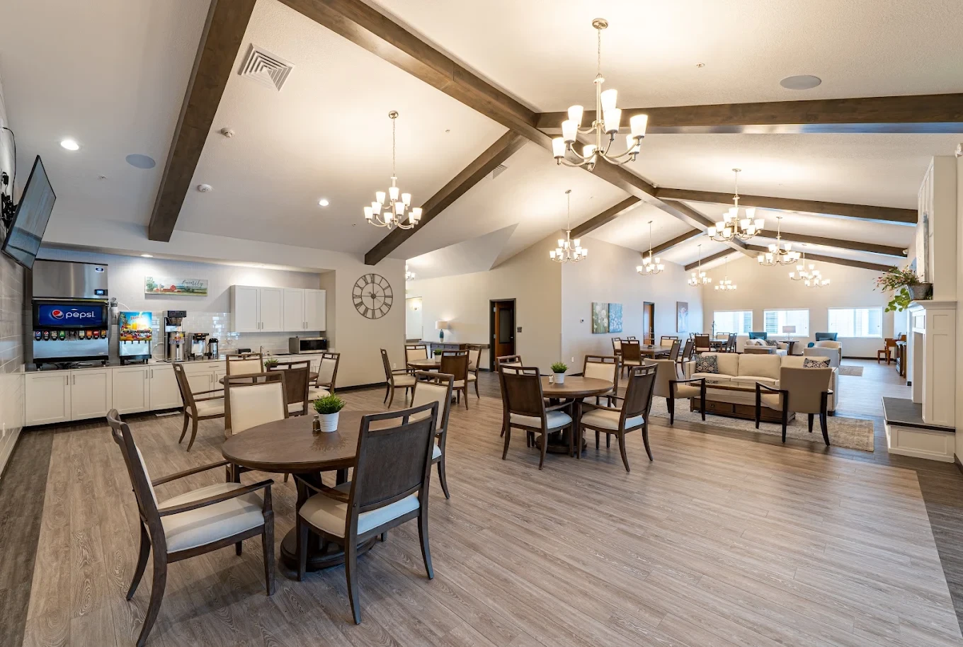 The dining room with round tables, a beverage station, and open seating area